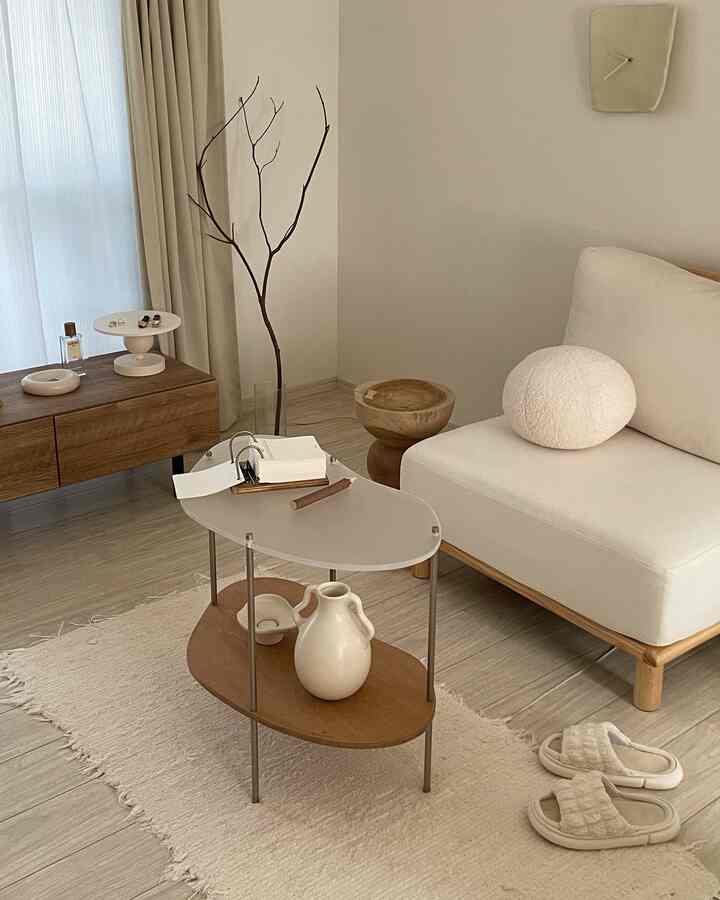 Beige and wood tone living room featuring low sofa, side table, and rug with a natural atmosphere
