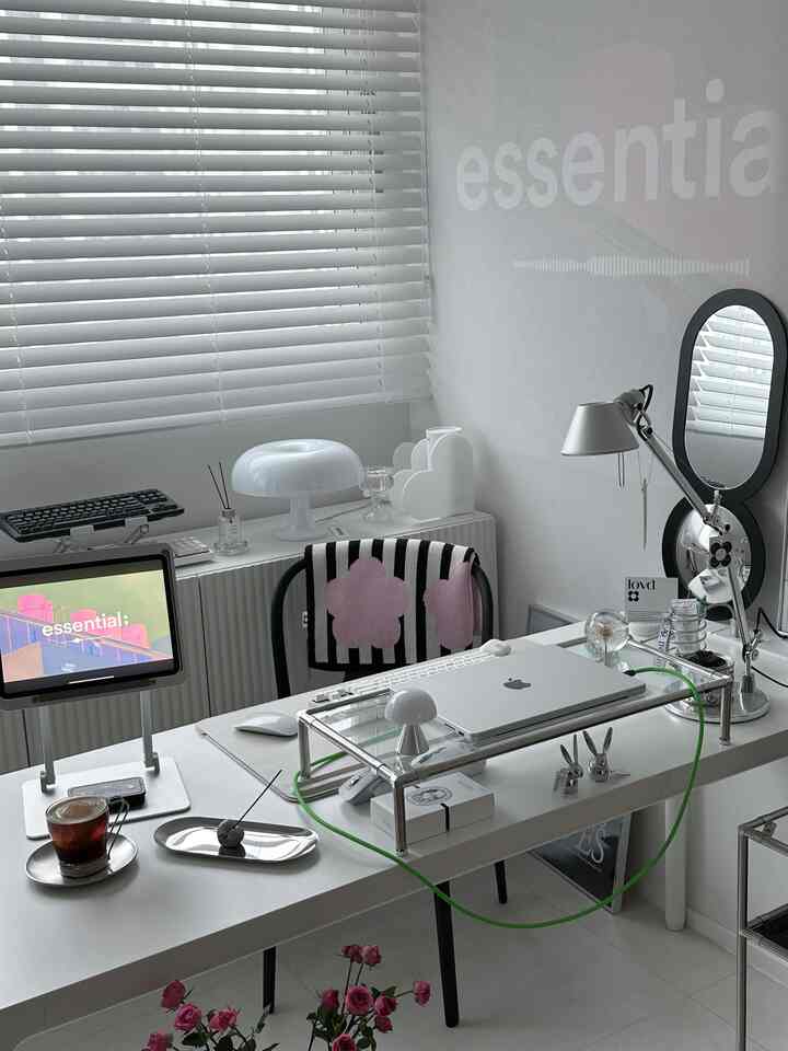 ホワイトトーンのホームオフィス、白いデスクとブラインド、モニタースタンドが配置されたミニマルでモダンな雰囲気のインテリア