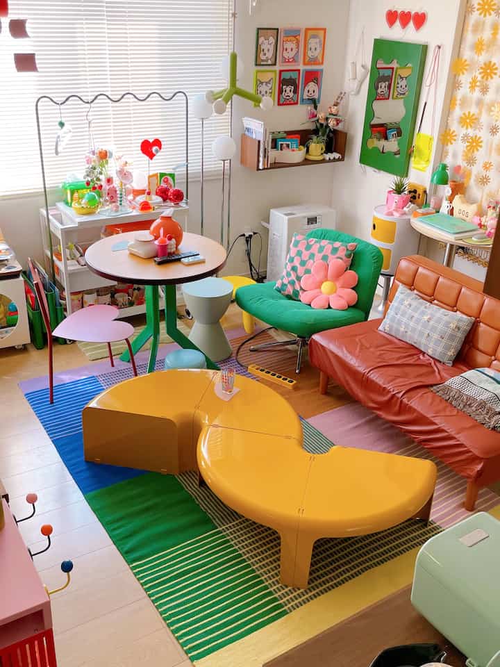 Bright and colorful living room featuring yellow curved coffee table and green armchair in a mid-century modern style