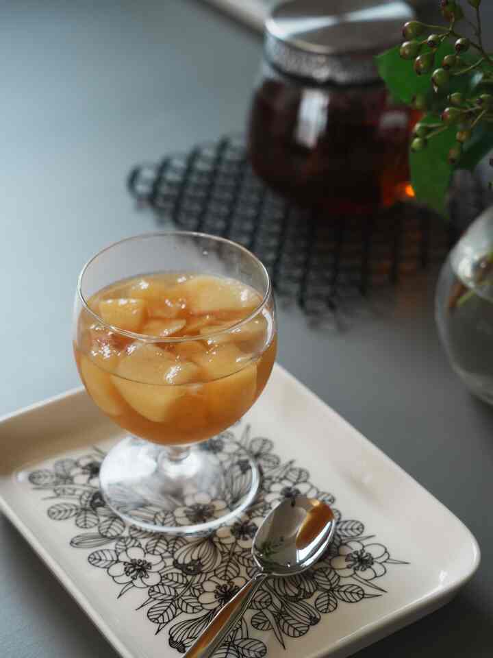 透明なグラスに入った桃ゼリーが置かれたアラビアの花柄デザート皿、落ち着いた雰囲気のテーブル上に配置されたインテリア