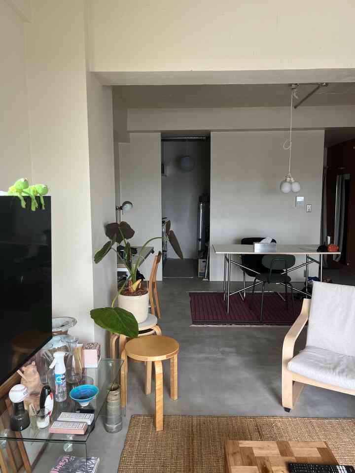 Bright cream and natural wood tone living room featuring minimalist furniture and large plant, creating a modern and natural atmosphere