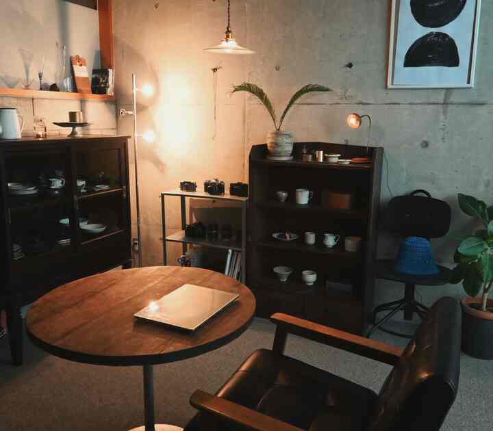 Warm brown and black toned living room featuring a wooden round table and vintage furniture with a natural cozy atmosphere