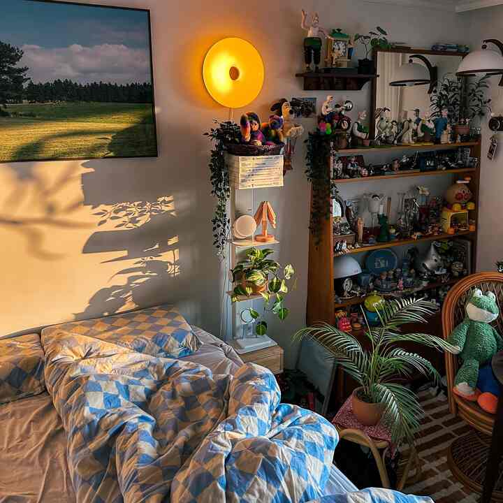 温かい夕日の光が差し込む、木製家具とヴィンテージトイが並ぶ寝室の印象的なインテリア