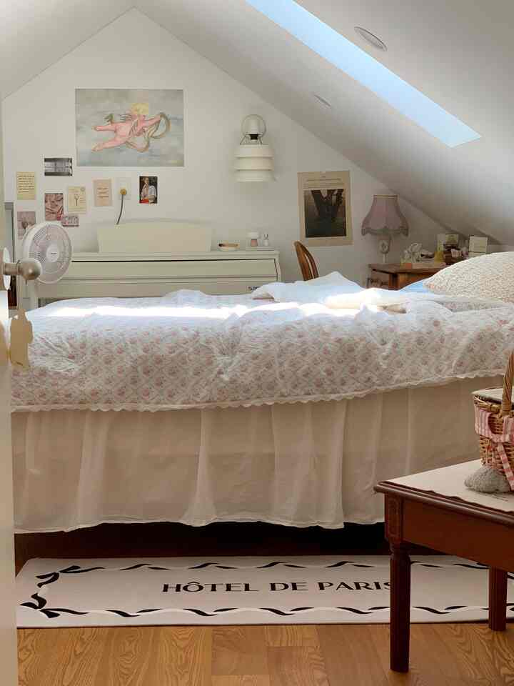 White and brown toned loft bedroom featuring floral bedding and vintage furniture, creating a cozy atmosphere