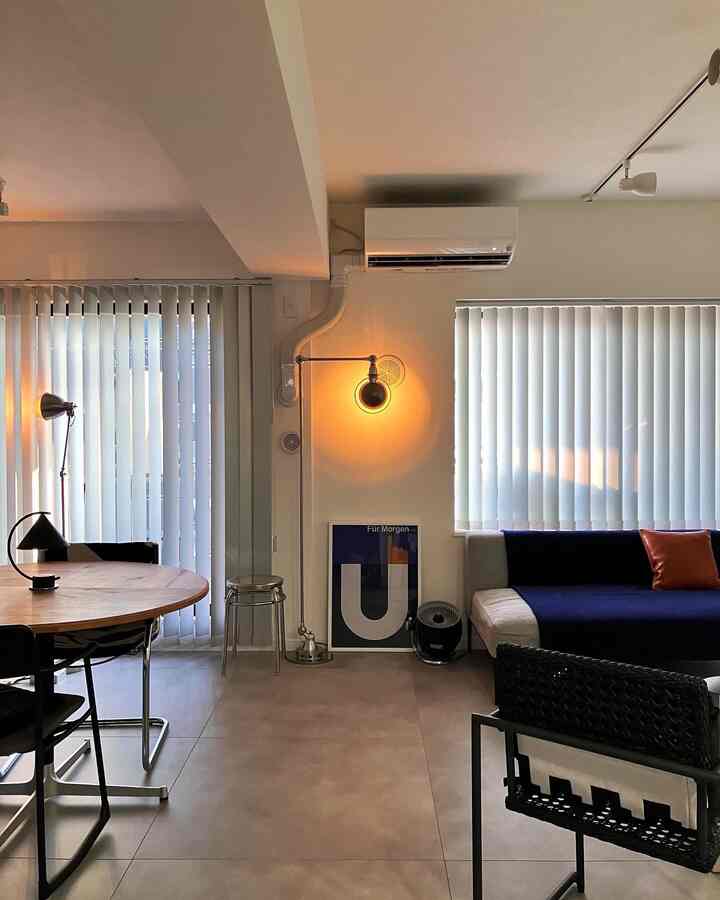 Modern living room in white and black tones, featuring a round dining table and floor lamp creating a calm atmosphere