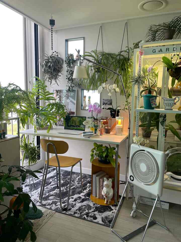 白と緑の色調のホームオフィス、デスクと多様な植物が配置された雰囲気のあるプランテリアインテリア