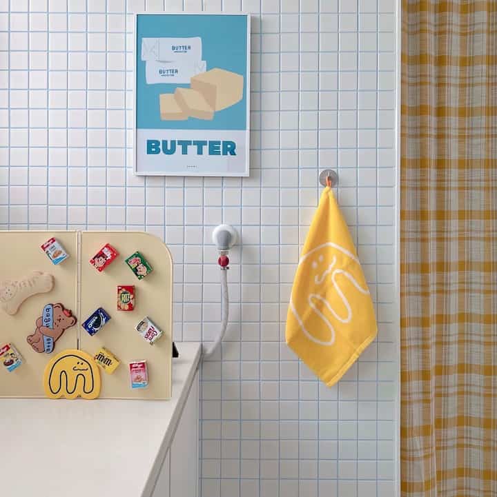 Auxiliary kitchen with white and yellow tones featuring a yellow kitchen towel and checkered curtains, creating a cute atmosphere