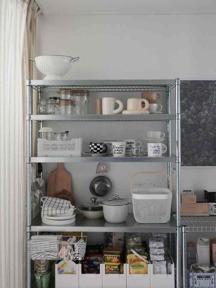 白とメタル調のキッチン棚、整然としたキッチン用品と食品が配置された雰囲気のあるインテリア