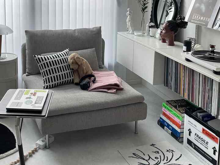 グレーの落ち着いた色調のリビング、中央にソファとターンテーブルが配置されたミニマルなインテリア