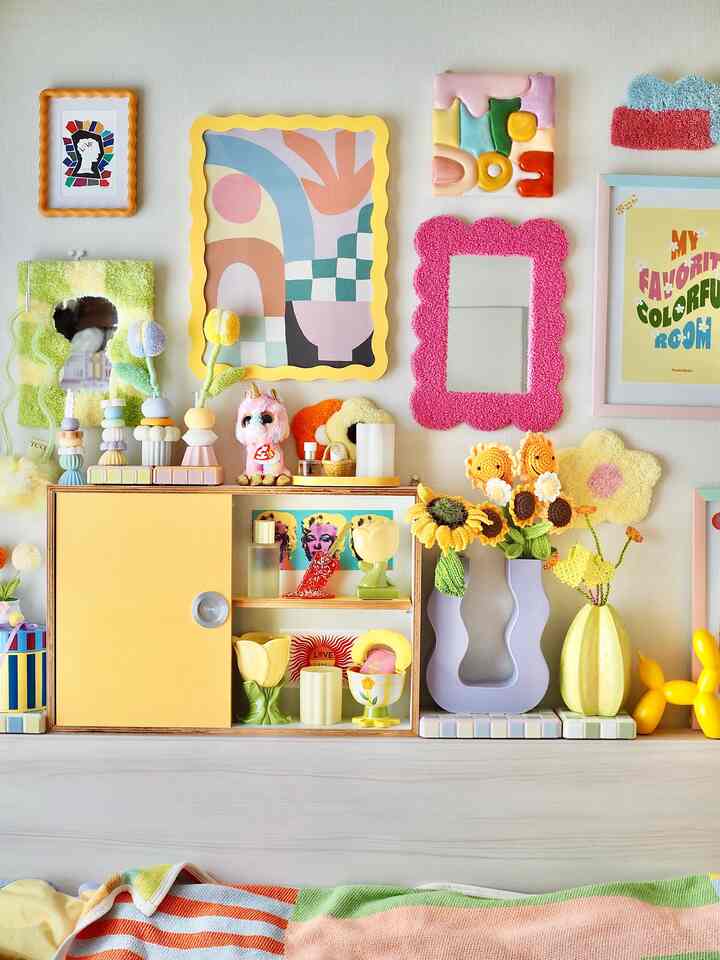 明るく鮮やかな黄色の壁と飾りが配置されたかわいらしいウォールアートの空間