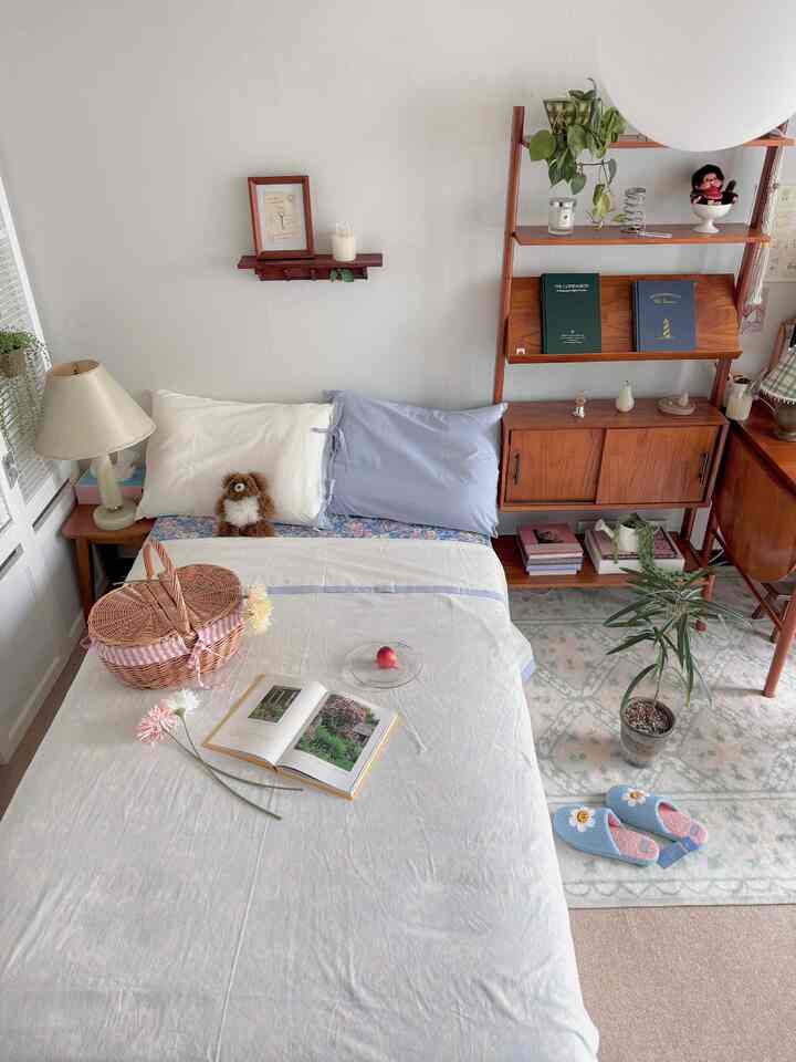 ホワイトと木目調の寝室、ヴィンテージ家具と植物が配置された雰囲気のあるインテリア