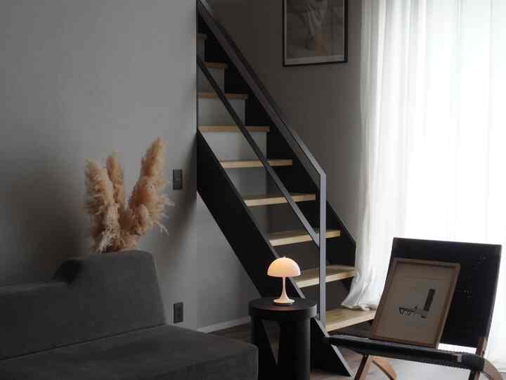 Natural-toned modern living room featuring Pantera table lamp, black armchair, and cozy atmosphere