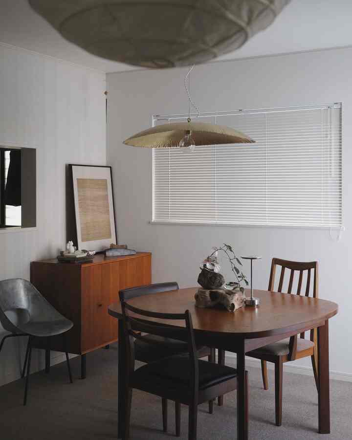 ブラウンの木製家具と白い壁、ブラインドが調和するモダンなダイニングルーム