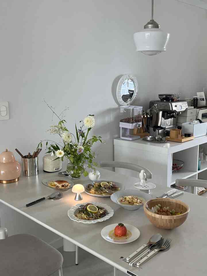 白と木目調を基調としたダイニングルーム、照明とホームカフェ設備が配置されたシンプルで明るい雰囲気のインテリア