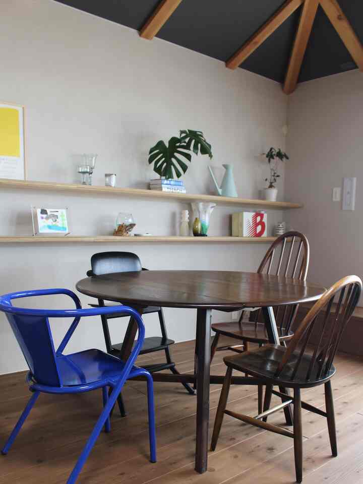 ナチュラルな色調と木目調が調和したダイニング、ヴィンテージ風のダイニングテーブルと多様な椅子が配置された温かみのある空間