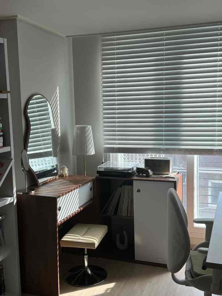 白と茶色のトーンのコンパクトなホームオフィス、化粧台、オフィスチェア、ターンテーブルが調和した雰囲気のあるインテリア