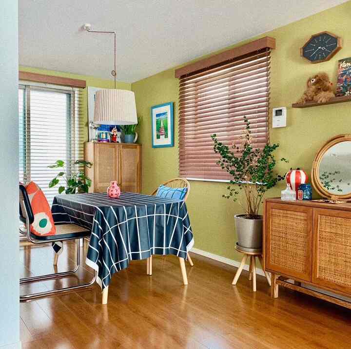 Light green walls and wood-tone furniture in a cozy Nordic style dining space