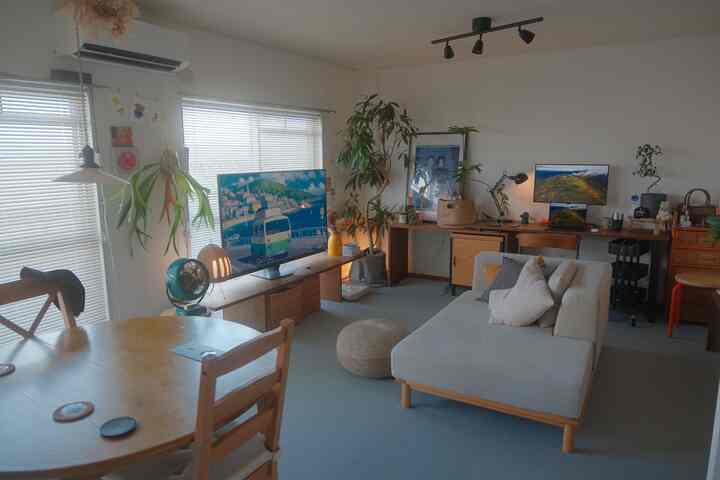 ナチュラルカラーとグリーンの植物が調和した二人暮らしのリビング兼ホームオフィス空間