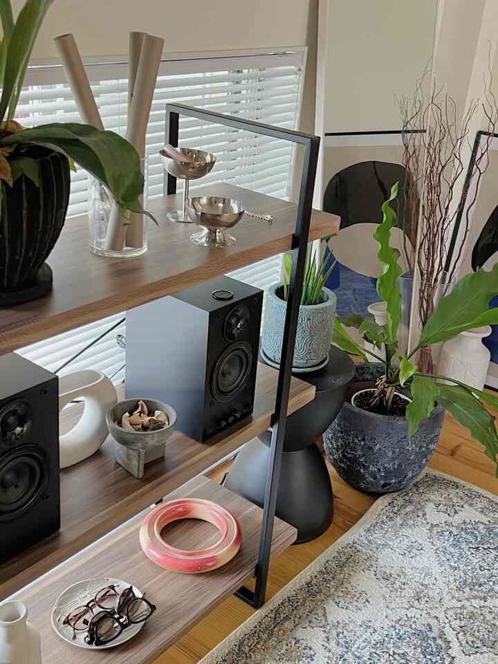 ナチュラルな木目調とネイビーの植物鉢が配置されたディスプレイラックとオブジェを特徴とする印象的なリビング空間