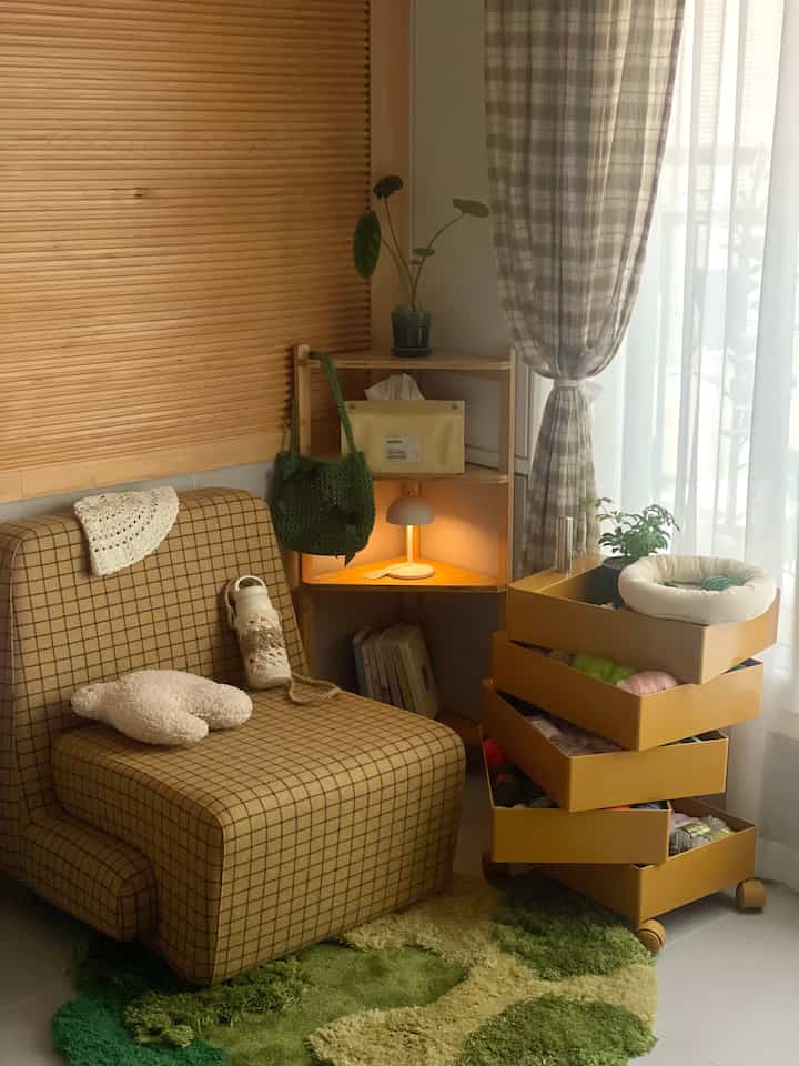 Natural modern living room with yellow trolley storage, checked sofa, and green rug creating a cozy atmosphere