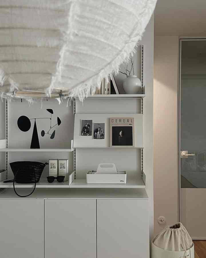 White and black monotone kitchen featuring wall shelves and storage cabinets with a simple modern atmosphere