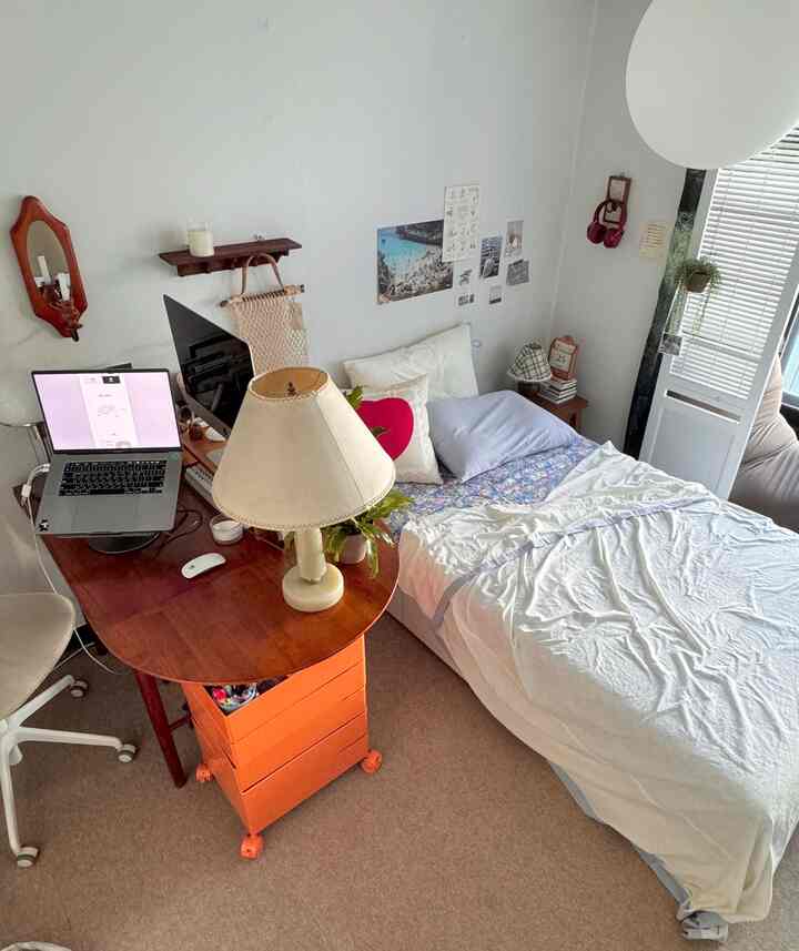 白とブラウンの木目調が配された、デスクとベッドのあるシングル向けホームオフィス兼寝室の印象的な空間