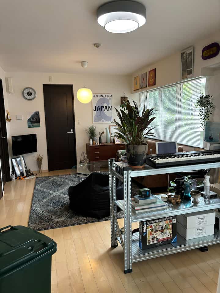 Bright wood tone living room featuring metal system shelves, vintage furniture, and a sofa for a cozy atmosphere