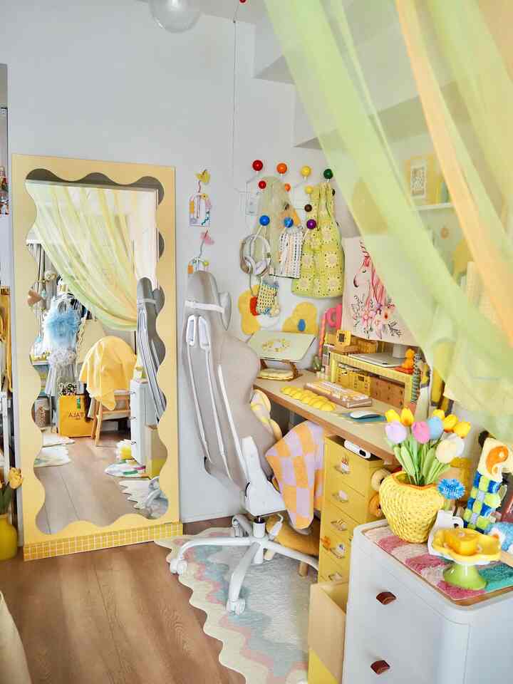 Yellow-toned natural color home office featuring a desk, ergonomic office chair, and wave mirror creating a cozy workspace