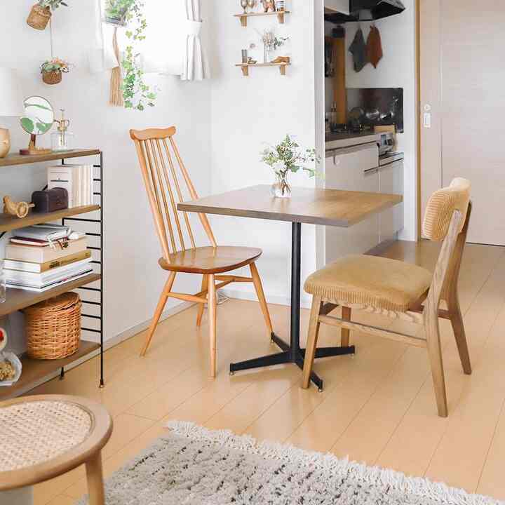 ナチュラルな色調のワンルームダイニング、カフェ風の正方形の食卓と木製チェアが配置された雰囲気のあるインテリア