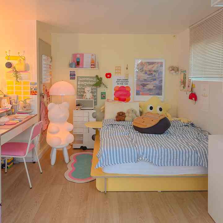 白と黄色の色調の寝室、クマ型照明とかわいい小物が配置された温かみのある空間
