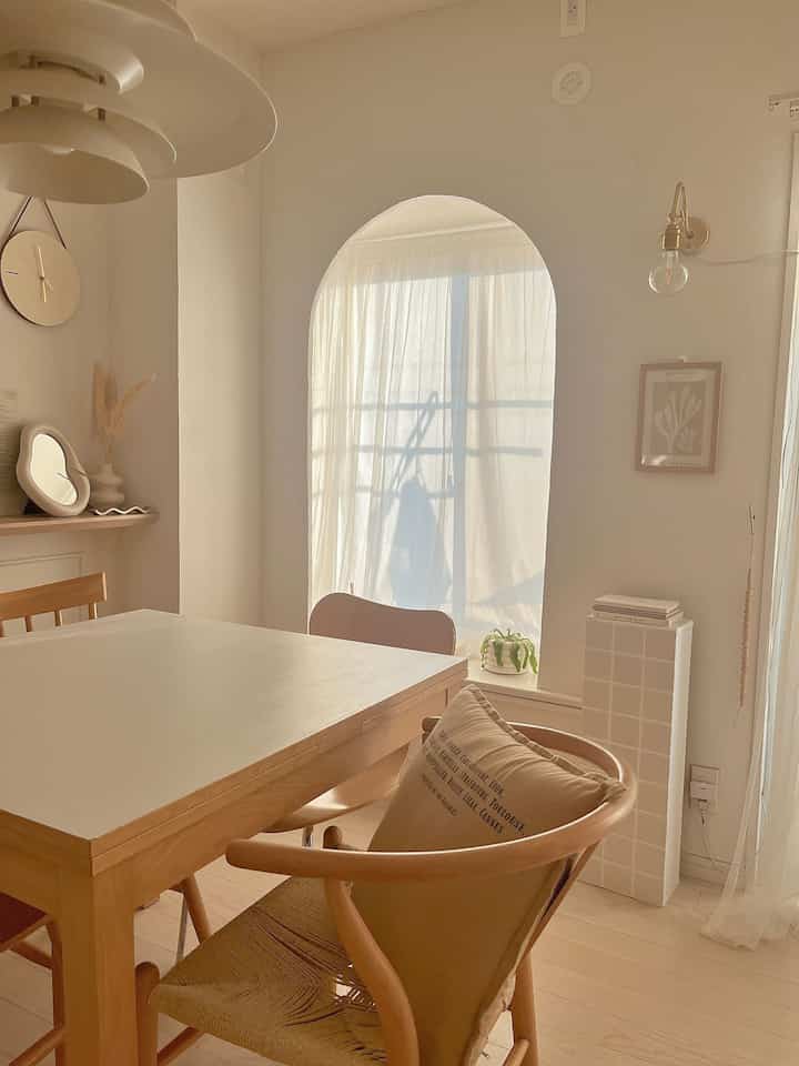 温かみのあるナチュラルカラーと木製家具のダイニング、壁の照明がレトロな雰囲気を演出するインテリア