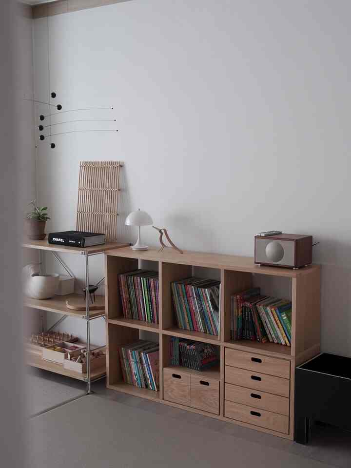 ナチュラルな木目調のリビング兼書斎、子供用本棚が整然と配置された落ち着きのある空間