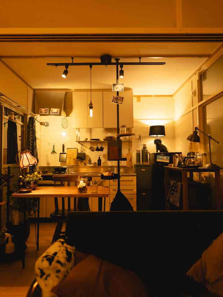 暖かい黄みのダイニングルーム、木製テーブルとヴィンテージ風ランプが調和したくつろぎの空間