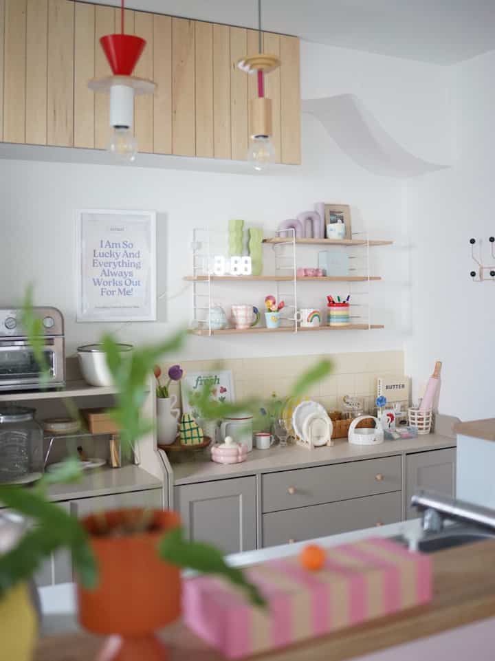 白と木目調が調和したキッチン、整然とした棚とキャビネットが配置された雰囲気のあるインテリア