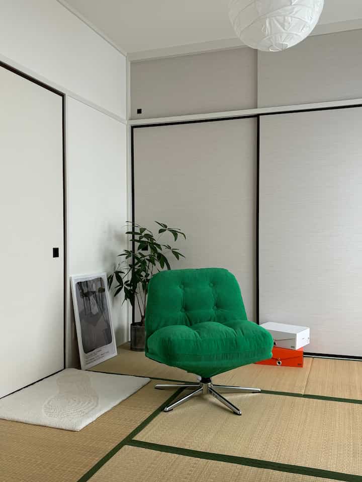 Bright green swivel armchair and plant in a traditional tatami room