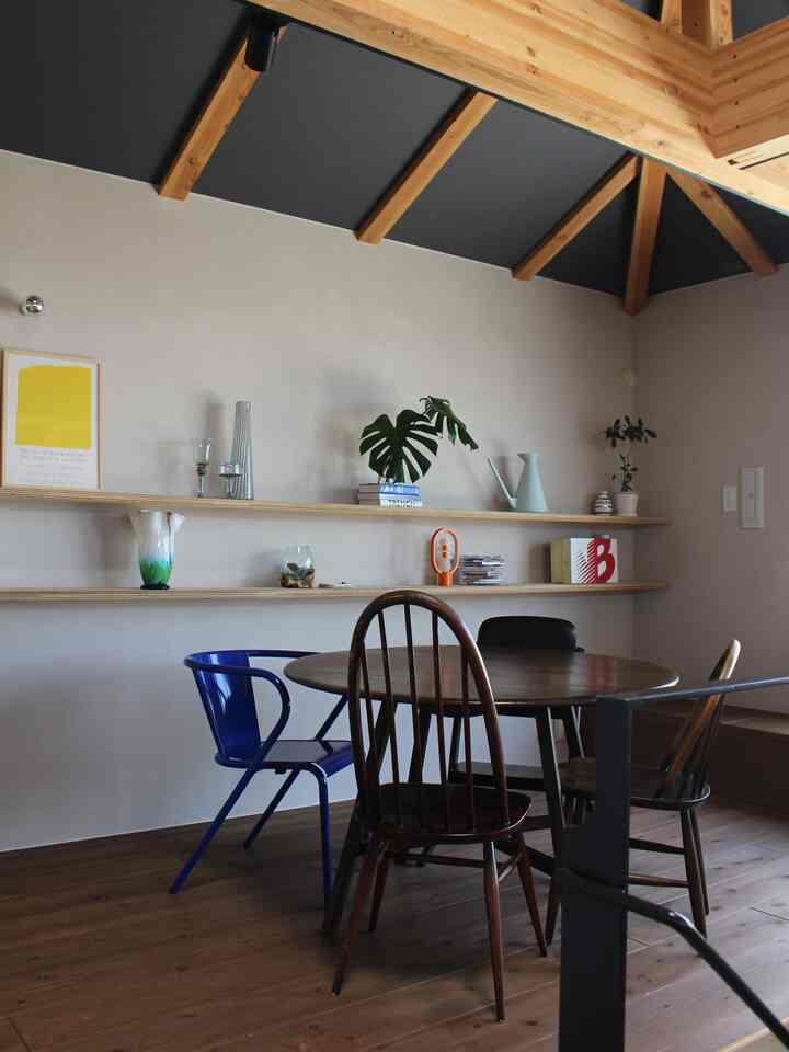 Natural wood tone and beige dining room featuring a round dining table with assorted chairs in a cozy setting