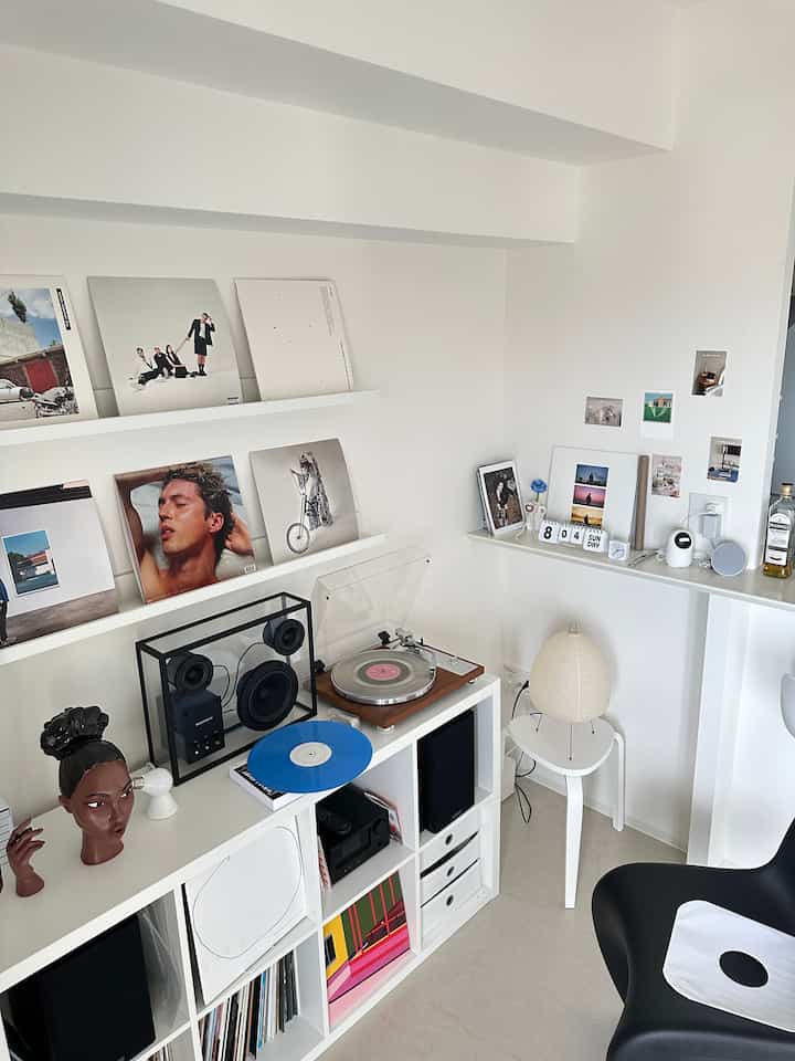 白を基調としたモダンな趣味空間、象徴的なLPレコードとスピーカーが配置された洗練されたインテリア