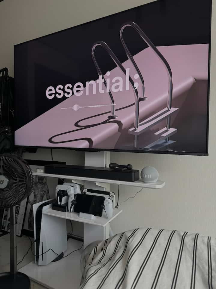 ホワイトとグレーの色調のゲームルーム、プレイステーションデジタル機器とテレビ台が配置されたモダンでシンプルな空間