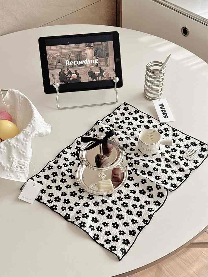 白いテーブルの上に花柄のキッチンタオル、コーヒーカップとシルバートレーが配置された雰囲気のあるおうちカフェ