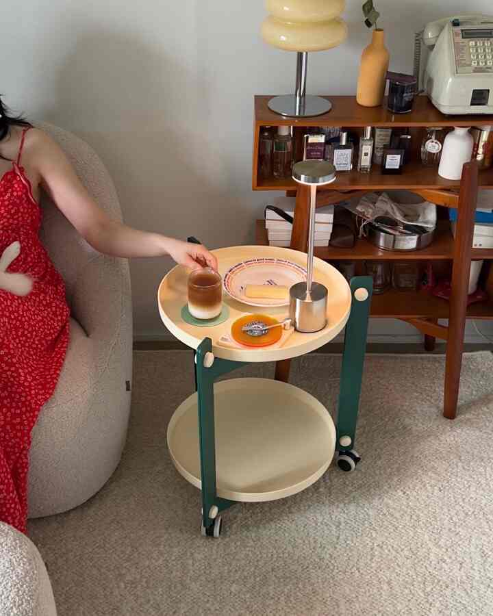 白とミント色調のリビングスペース、サイドテーブルにコーヒーとスナックが置かれた雰囲気のあるカフェ風インテリア