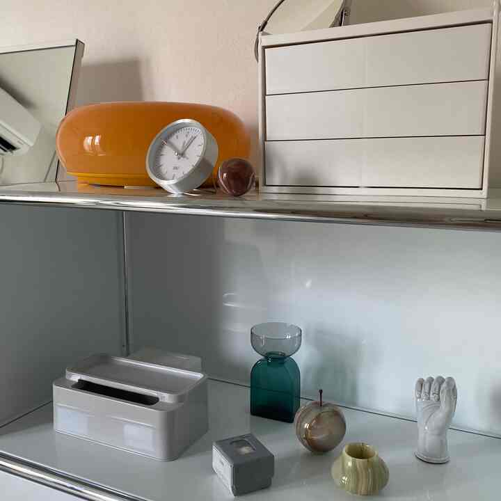 白と黄色の色調の収納ボックスとオブジェが配置された、すっきりとしたミニマルなインテリア空間