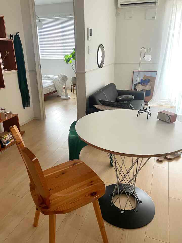 White and wood tone living room featuring a round table and sofa in a mid-century modern style