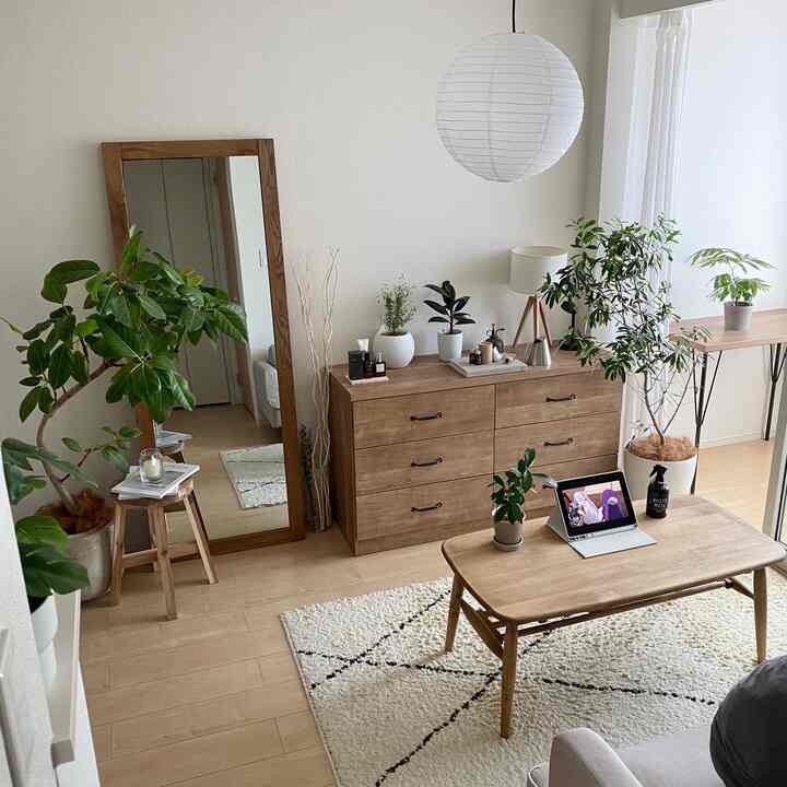 ナチュラルな色調の1LDKリビング、木製家具と緑豊かな植物が配置された落ち着いた雰囲気のインテリア