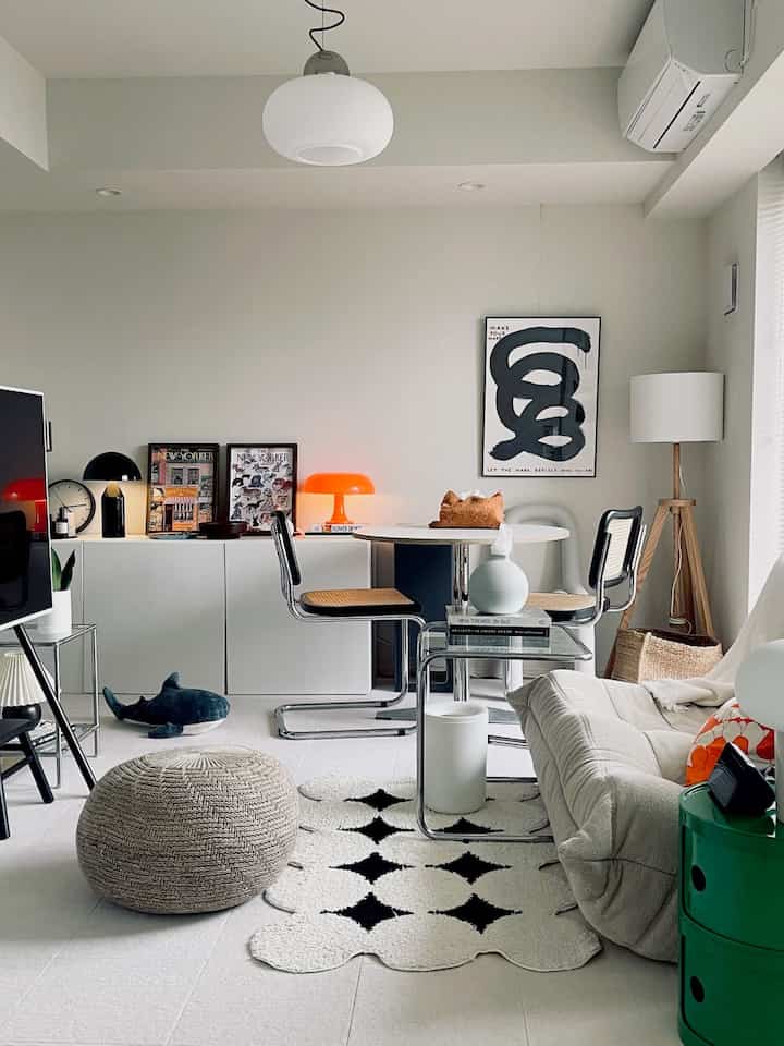 白とベージュのトーンの2Kリビング、丸いダイニングテーブルと椅子、ソファが配された雰囲気のある空間