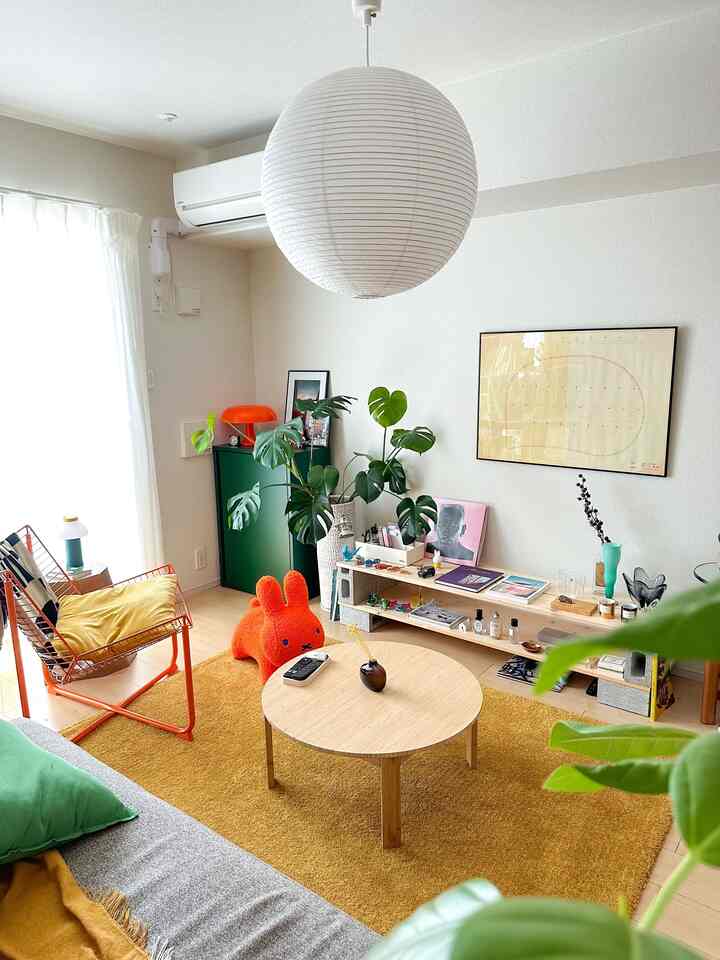 Yellow and green toned living room featuring a round coffee table and plants with a cozy, bright atmosphere
