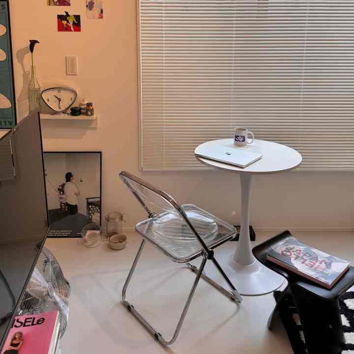 White and transparent studio apartment cafe-style space featuring blinds and minimal furniture with a clean interior