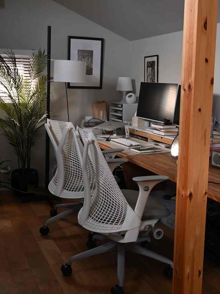 ブラウン調のナチュラルモダンな書斎、ハーマンミラーのオフィスチェアとモニタースタンド、フロアランプが配置された居心地の良いホームオフィス