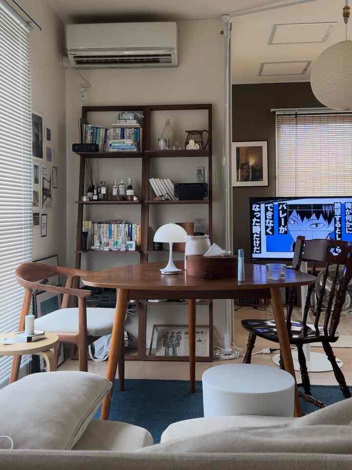 ブルーのラグと木製ダイニングテーブルが配置されたナチュラルなトーンのダイニングルームで、暖かく居心地の良いリビングスペース