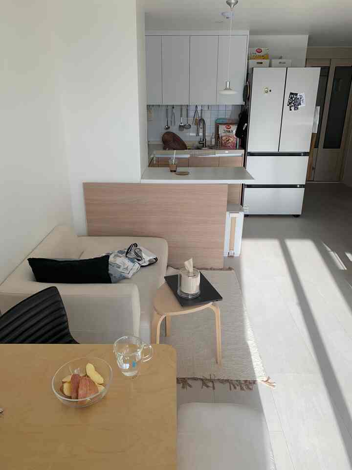 白と茶色の調和が取れたナチュラルモダンな小さなリビングとキッチンの印象的な空間