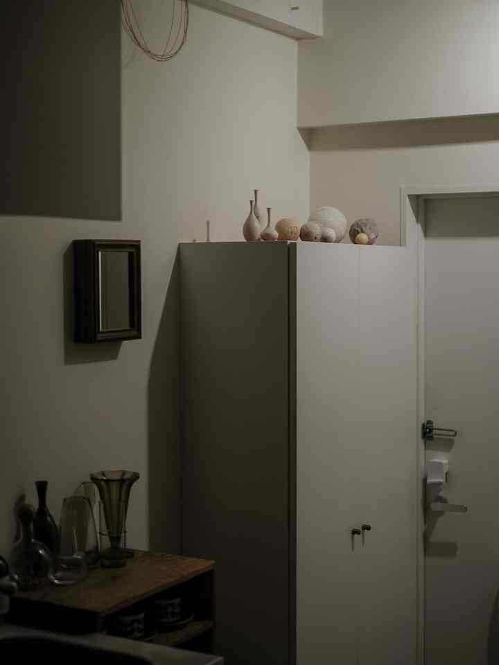 Beige-toned entrance featuring a storage cabinet topped with vases, creating a natural compact space impression